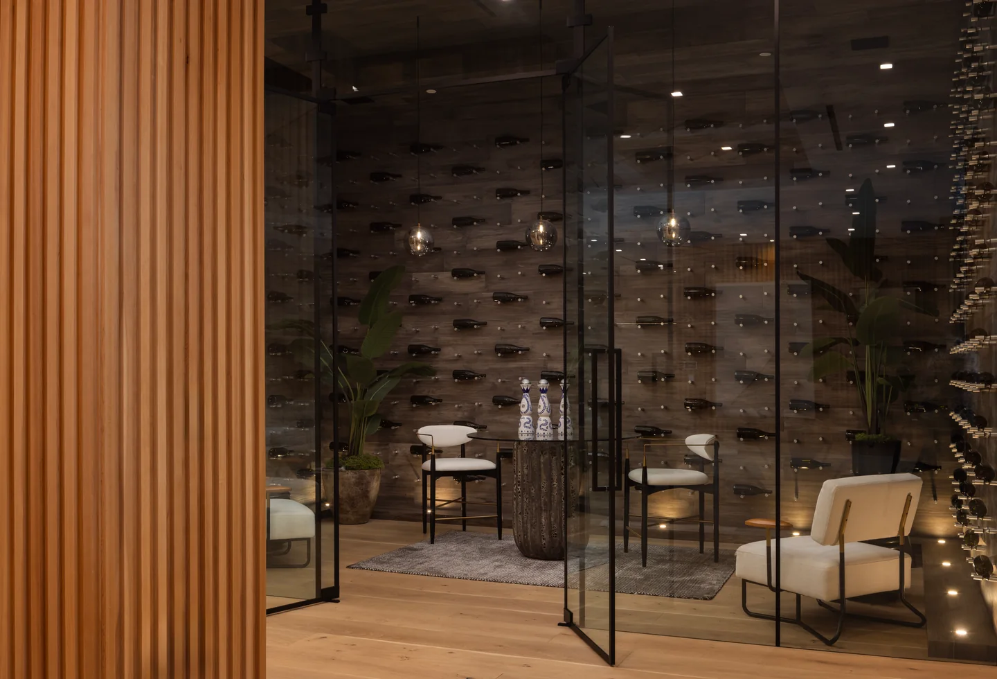 Chalon Road wine room behind glass doors, framed by vertical timber panels and a timber-lined ceiling.