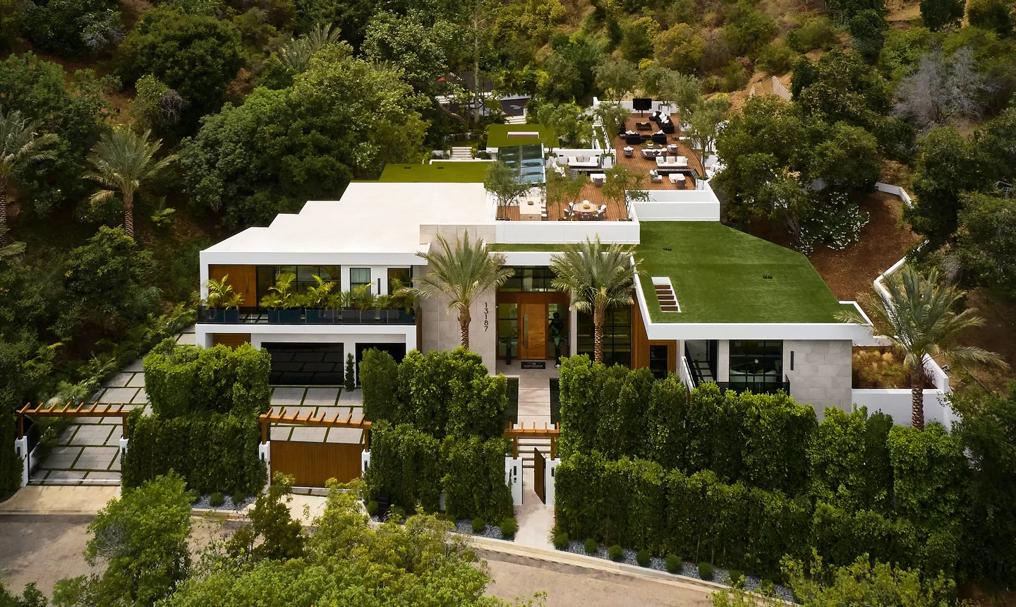Chalon Road residence viewed from the front above the entrance, with stepped white volumes, planted roofs and trees.