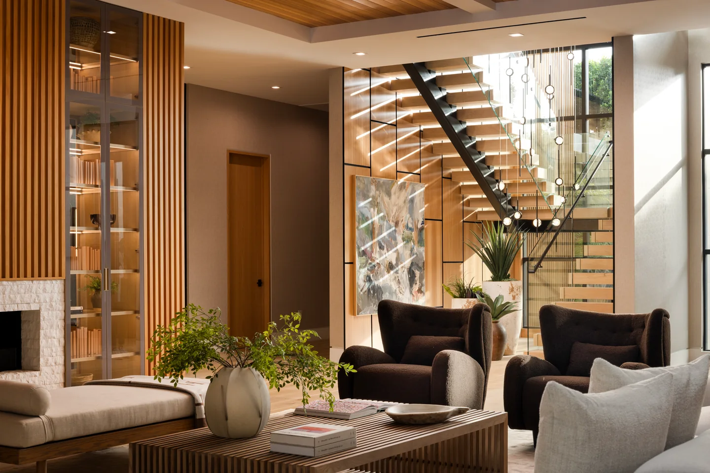 Chalon Road interior with an open timber stair, glass guardrail, stone feature wall and tall timber paneling.