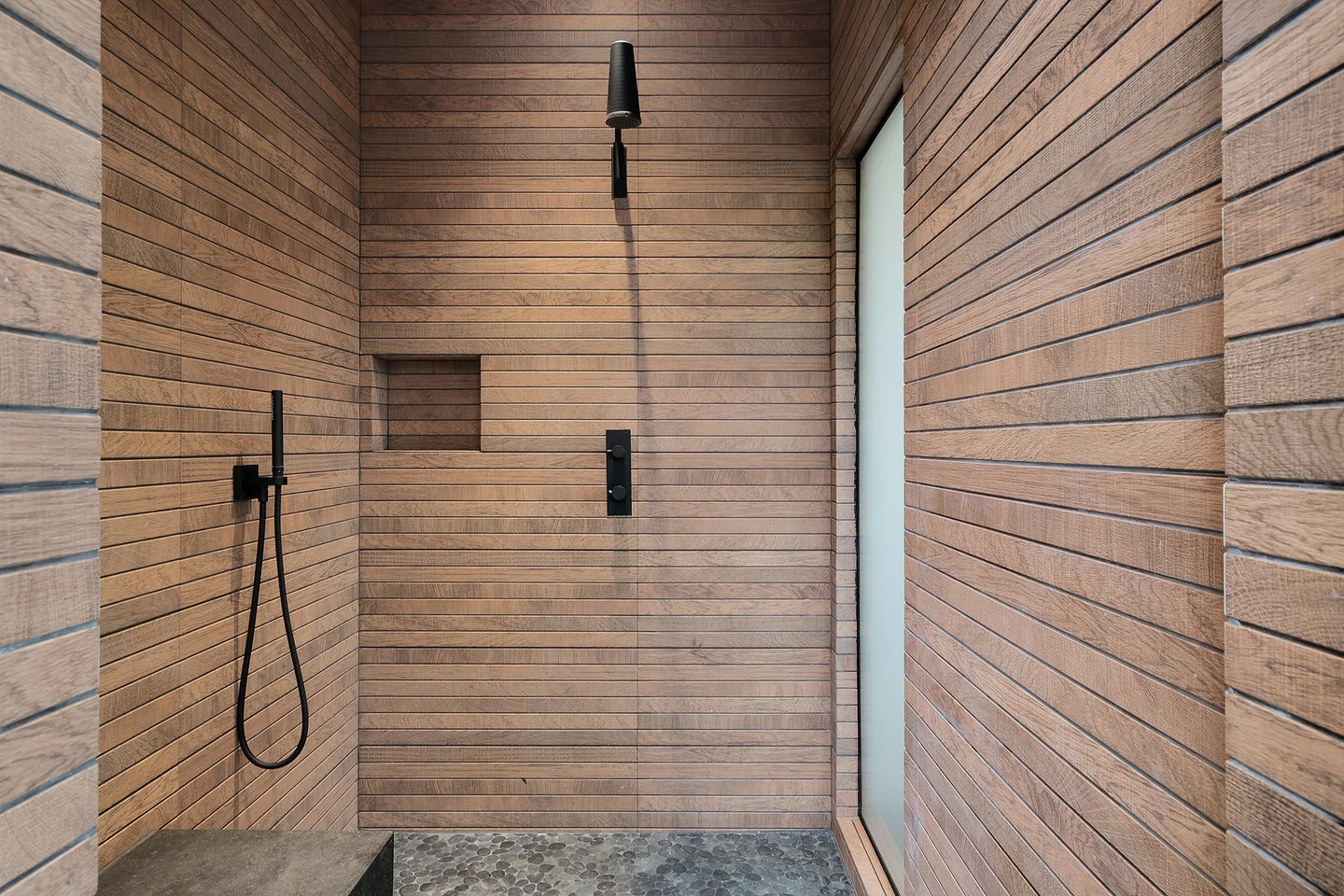 Walk-in shower with horizontal wall panels, a built-in bench and dark plumbing fixtures.