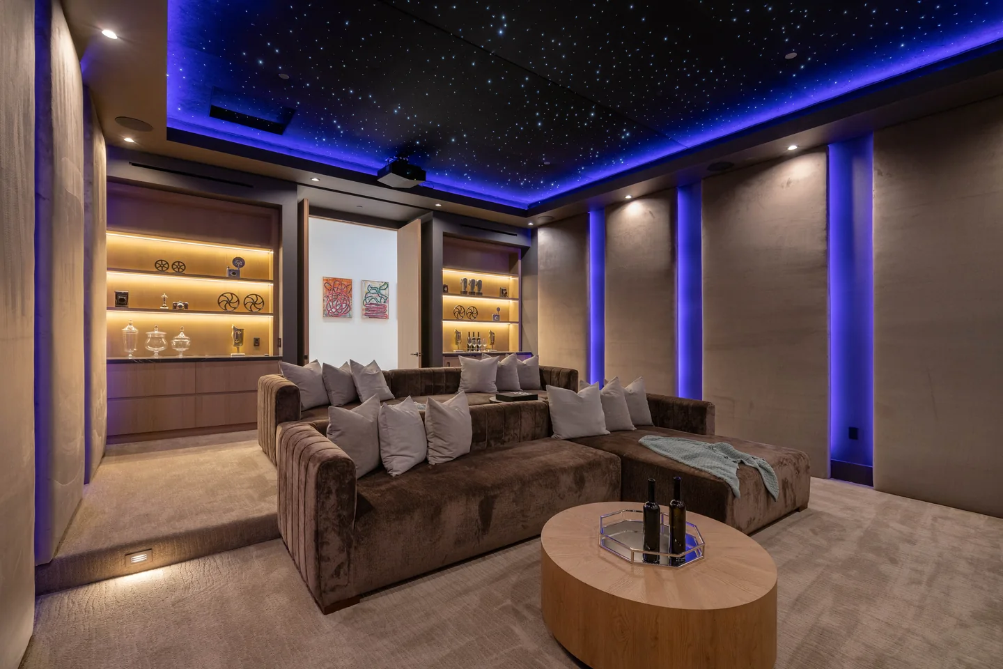 Home cinema with tiered seating, illuminated built-in cabinetry and a star-like ceiling.