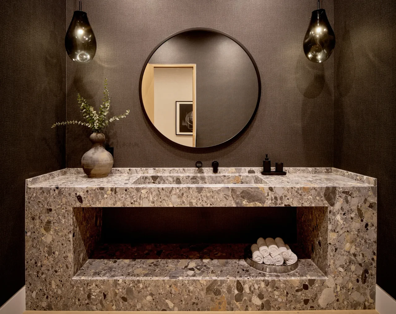 Powder room with stone basin and round mirror at Chalon Road.