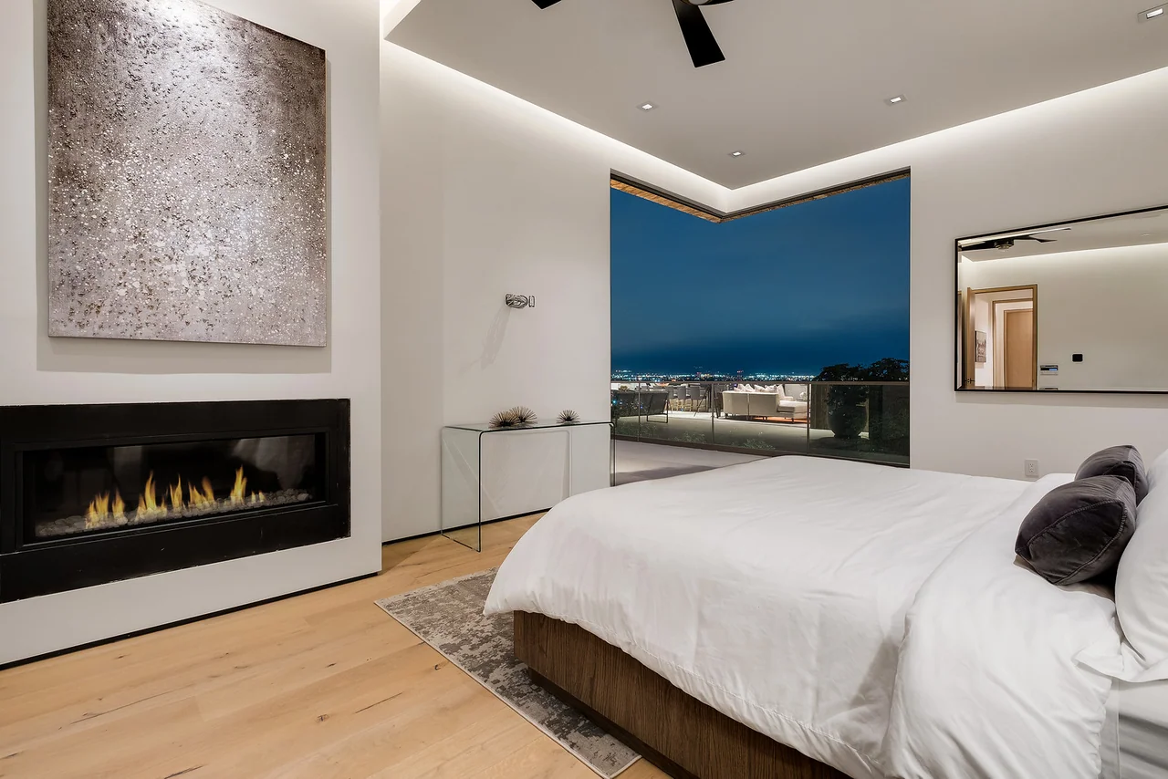 Bedroom with fireplace and corner glazing at Dixie Canyon.