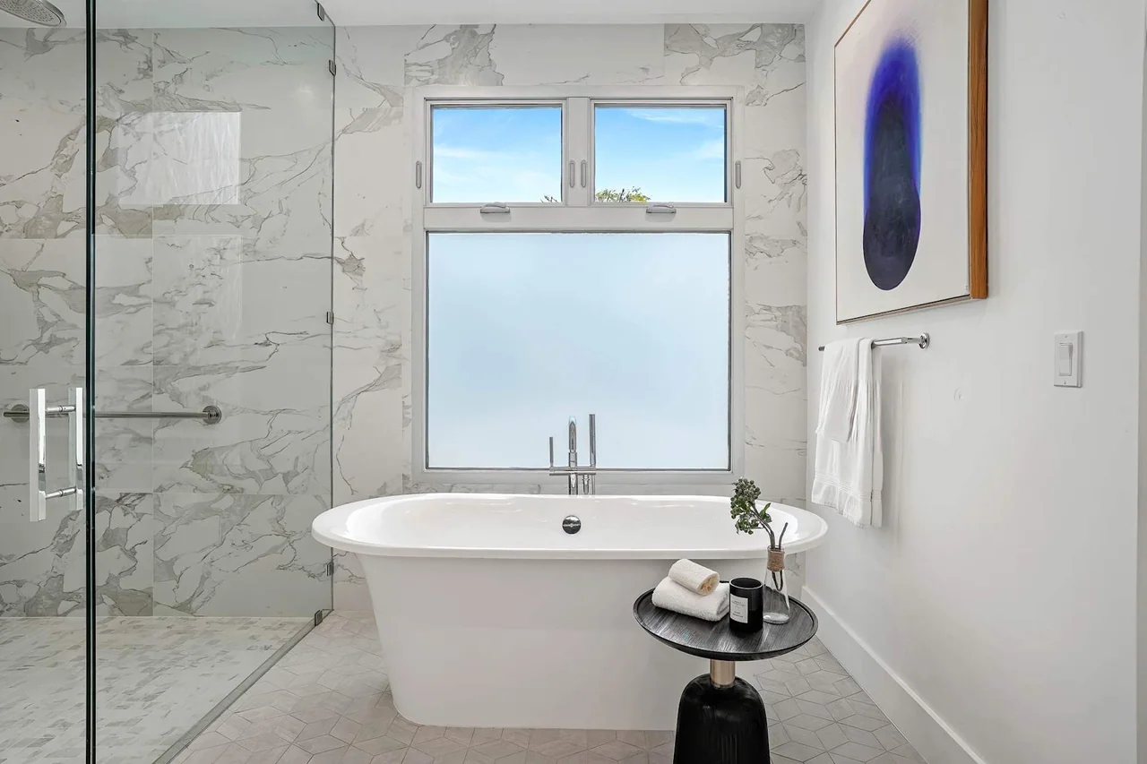 Bathtub beside a glass shower at Fairburn Avenue.