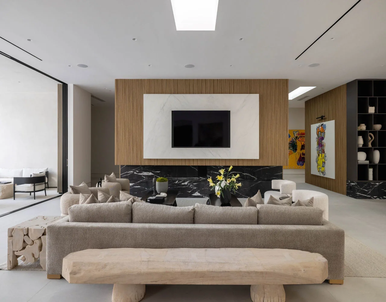 Living room with timber-paneled fireplace wall at Petit Avenue.