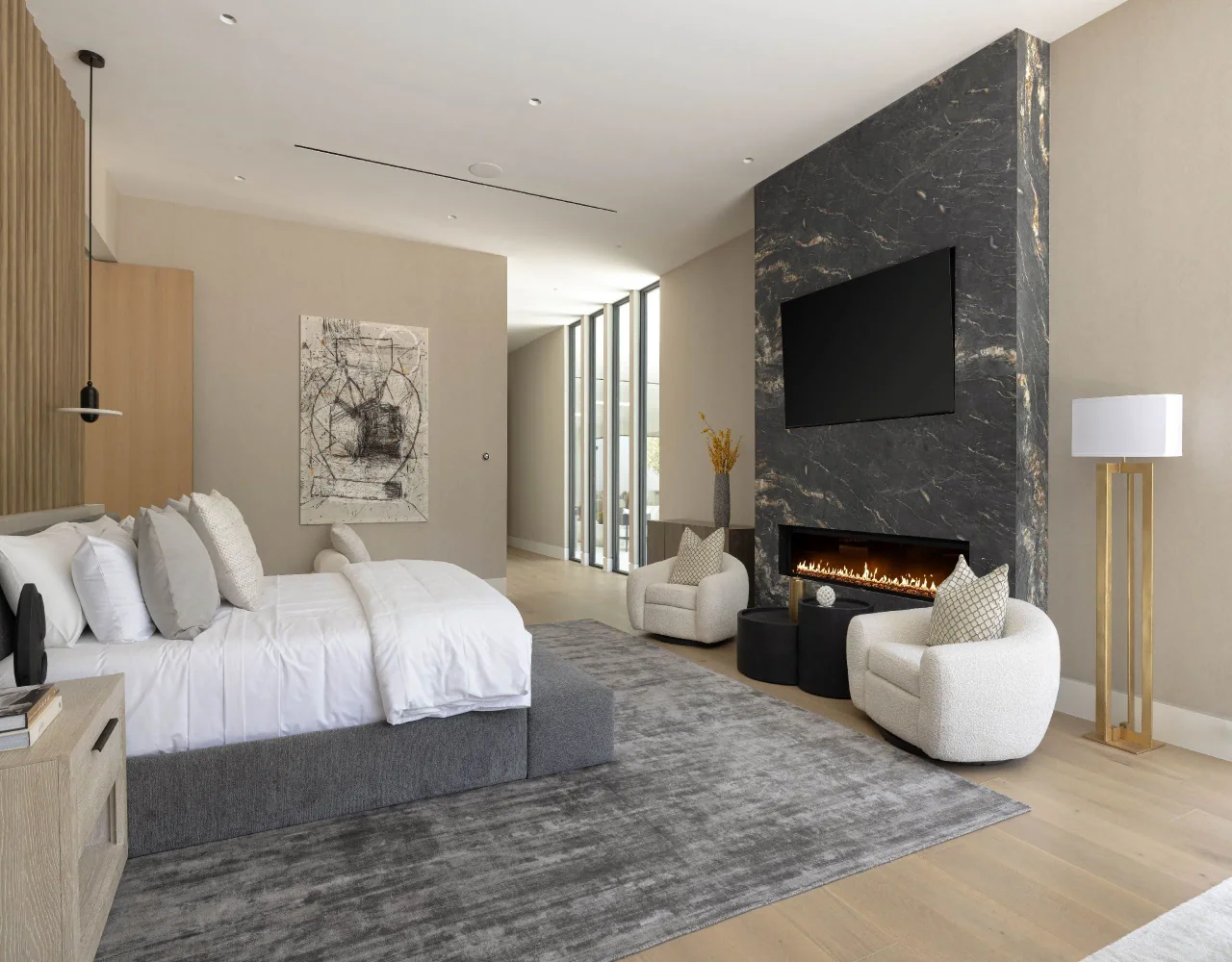 Bedroom beside a stone fireplace at Petit Avenue.
