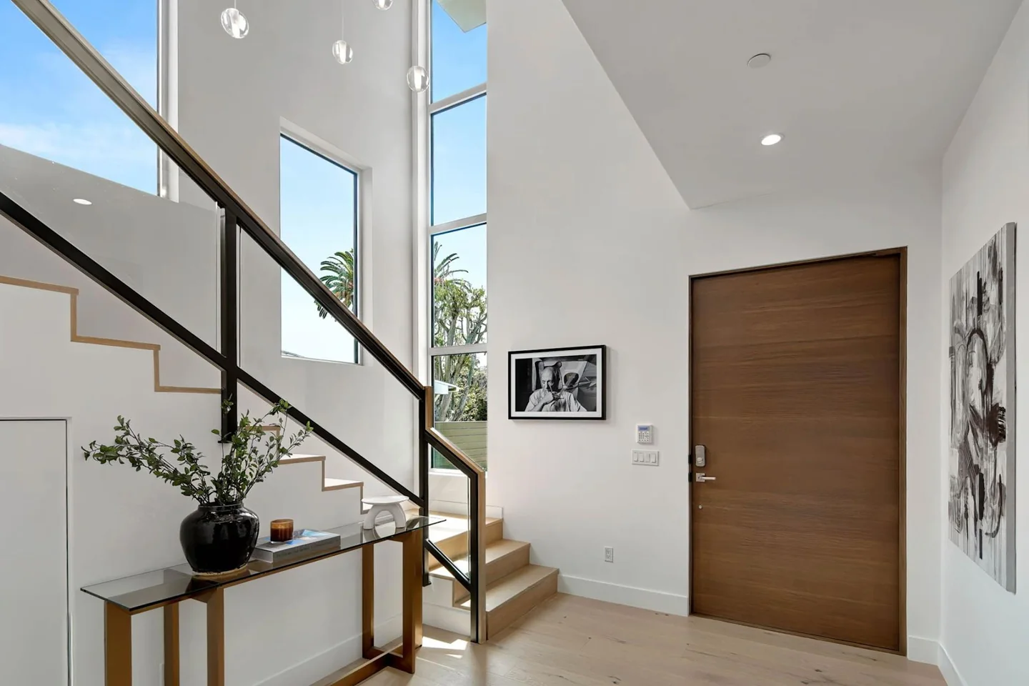 Timber steps at Fairburn beside tall glazing, with a dark handrail and clear glass panels.