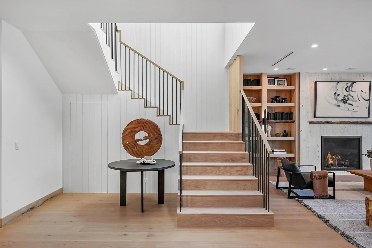 South Gretna Green timber stair with slender dark balusters, vertical timber fins and adjoining fireplace shelving.