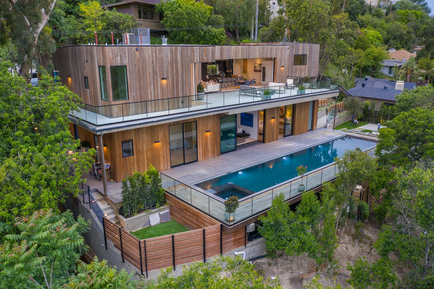 Dixie Canyon residence with timber-clad levels, long glass terraces and a pool set among hillside trees.