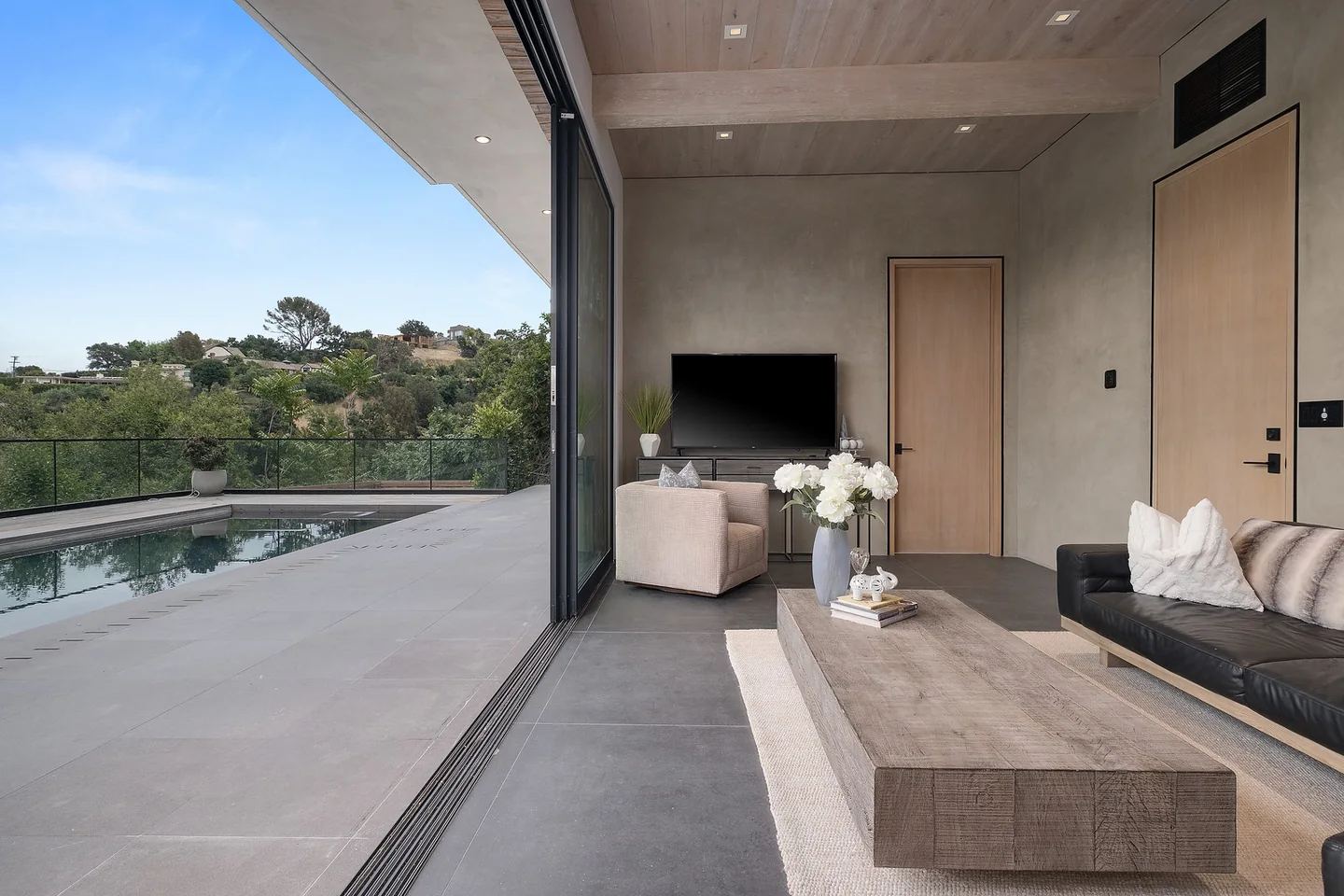 Dixie Canyon covered terrace with a timber ceiling, glazed balustrade and hillside view.