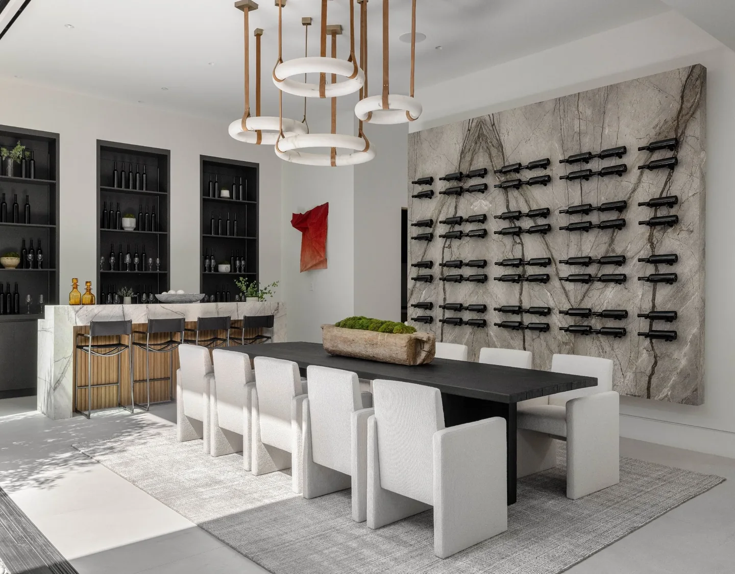 Petit Avenue dining space with veined wall surfaces, dark shelving and a wall-mounted wine display.